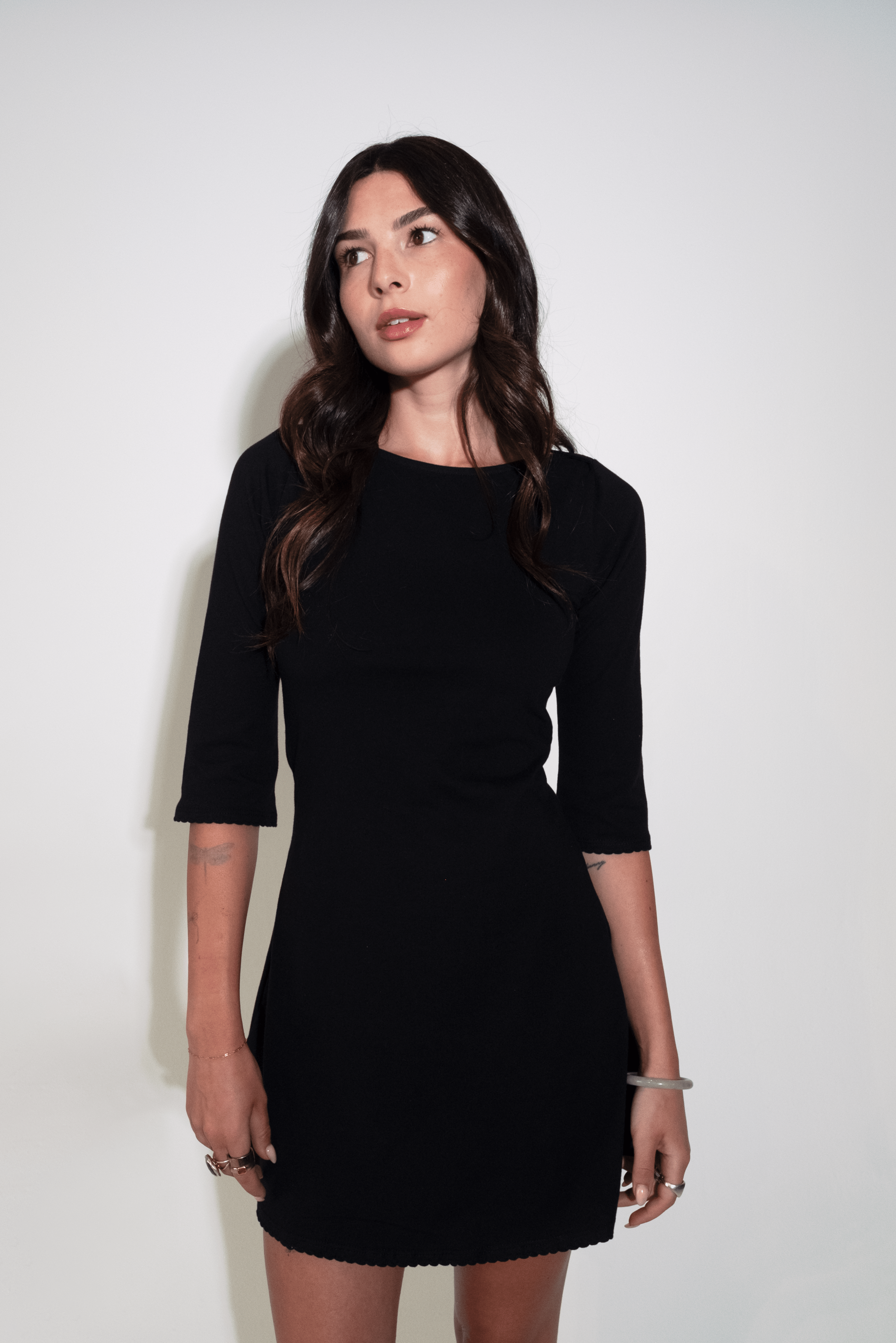 Woman wearing a black dress against a white background