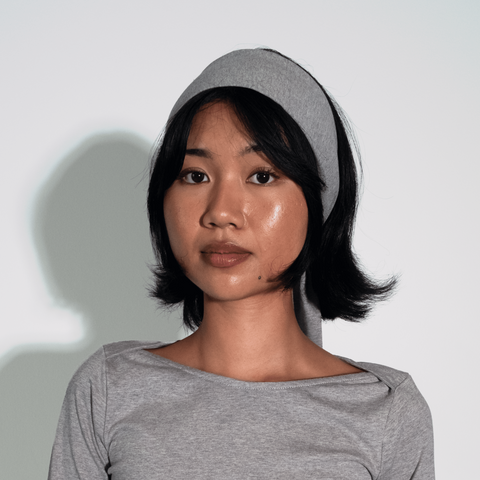 Woman wearing a gray dress against a white background